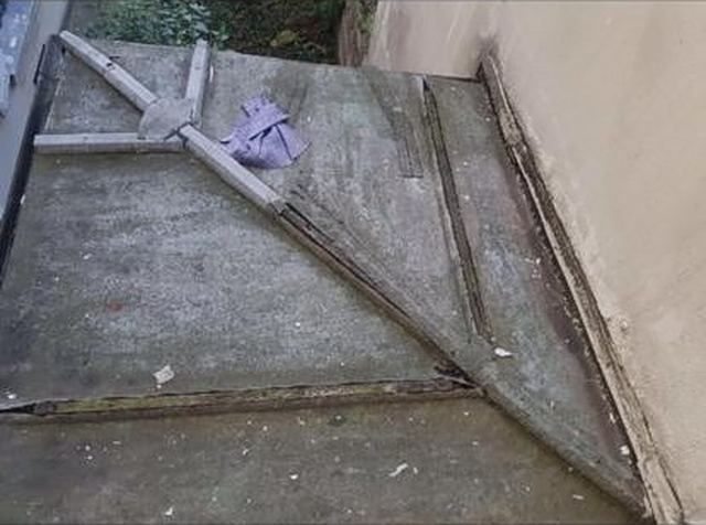 Ancienne couverture d'un petit toit adossé à un mur : surface encrassée, tasseaux et relevés abîmés, secteur de Fosses